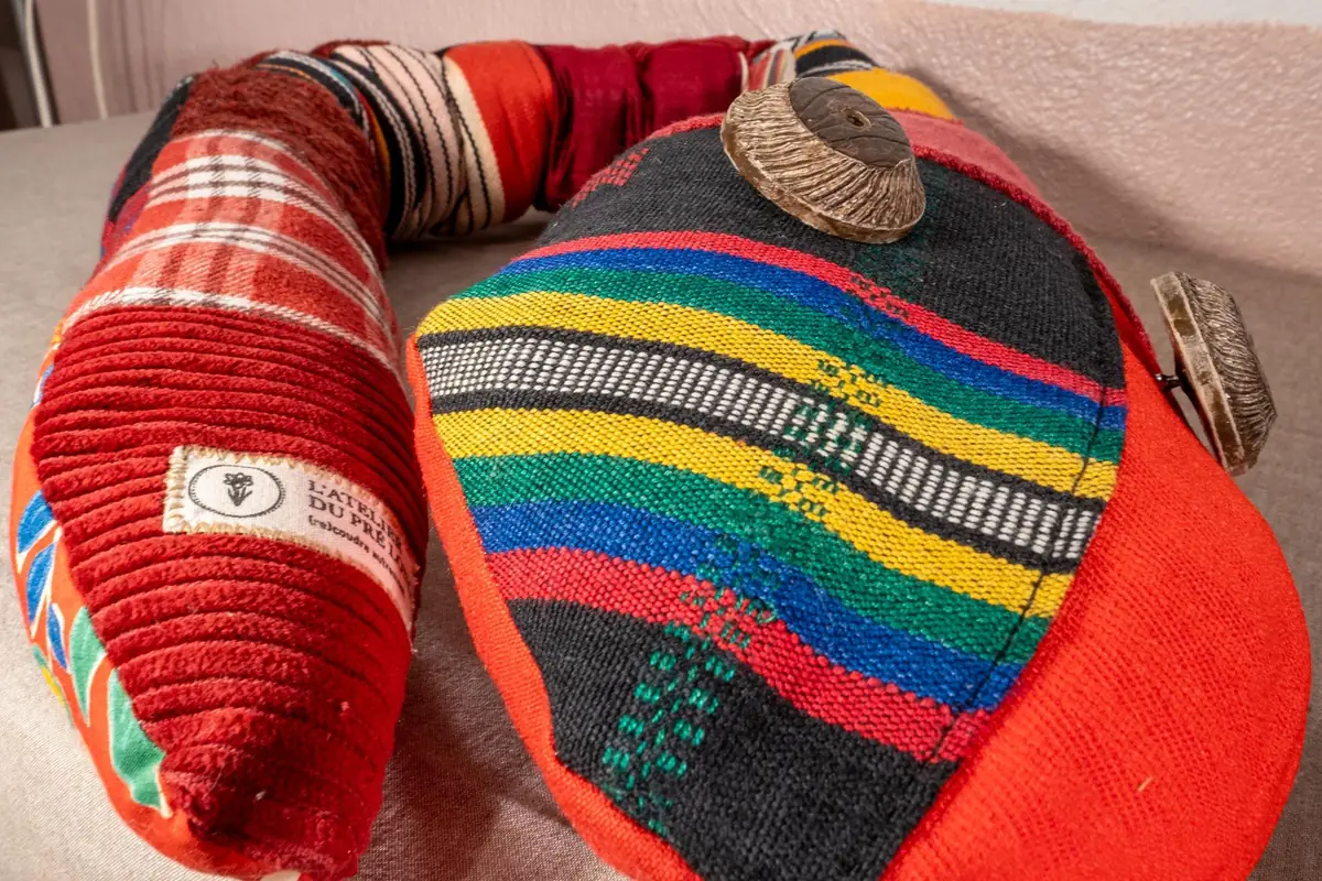 Gros plan sur un serpent décoratif rouge en tissus rayés multicolores